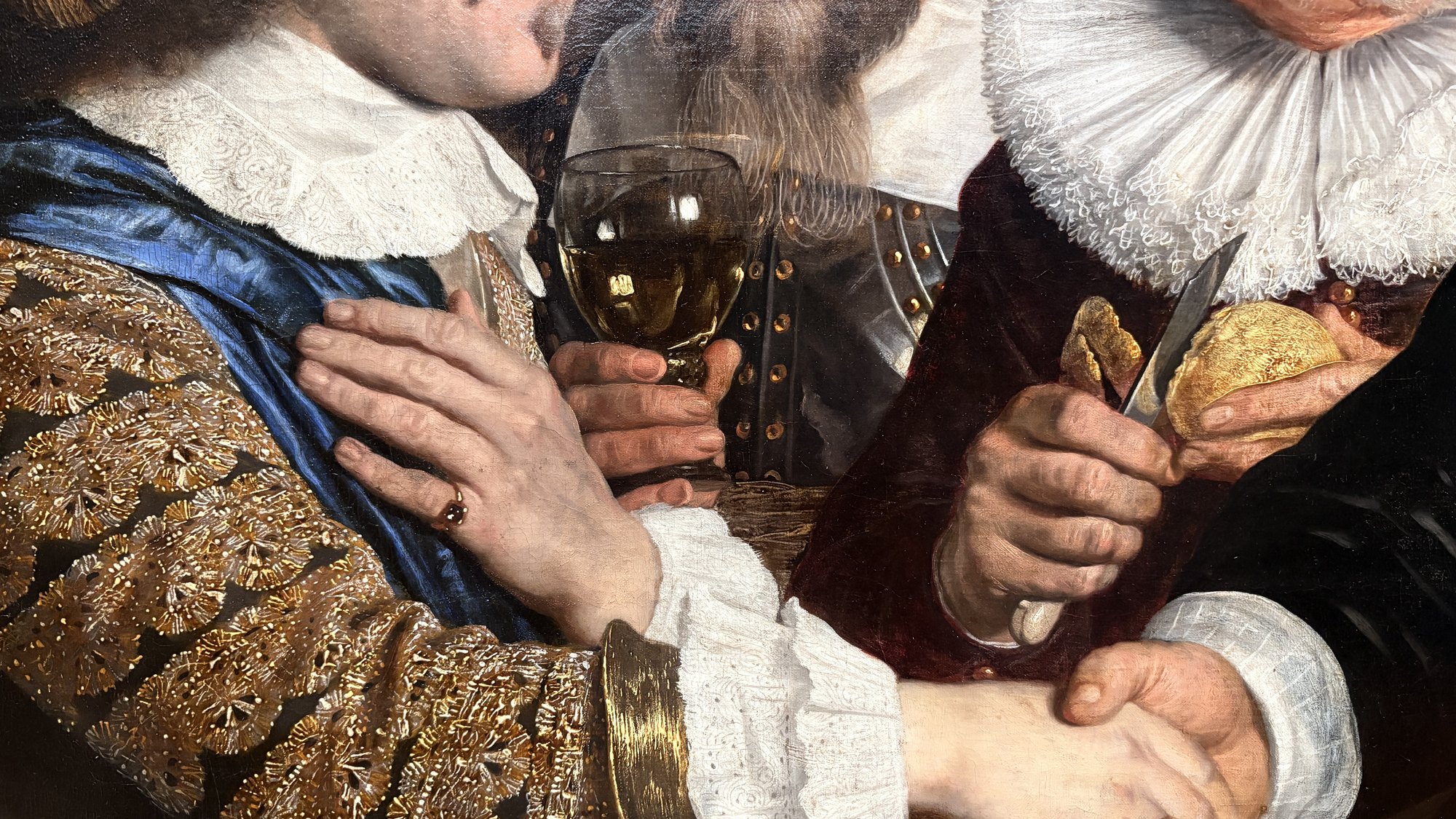 Handshake between two officers, lace cuff and glass of wine, detail from Van der Helst's civic-guard banquet